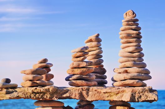 Balancing of several piles of pebbles on a boulder