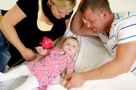 Mother and father are looking at their sweet smiling 4 month old baby.