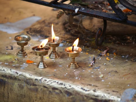 Candles burning in dark indoor Buddhism temple        