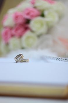 rings and beautiful flower bouquet on wedding notebook for guest