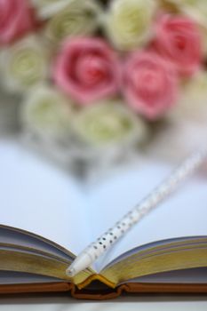 rings and beautiful flower bouquet on wedding notebook for guest