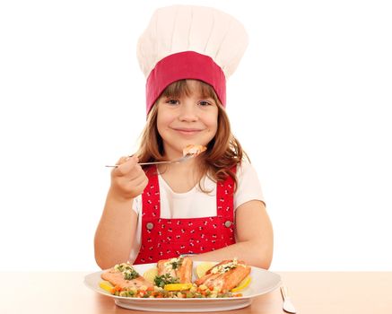 hungry little girl cook eating salmon