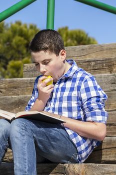 Lifestyle.Young boy reading a book in wooden stairs, summer