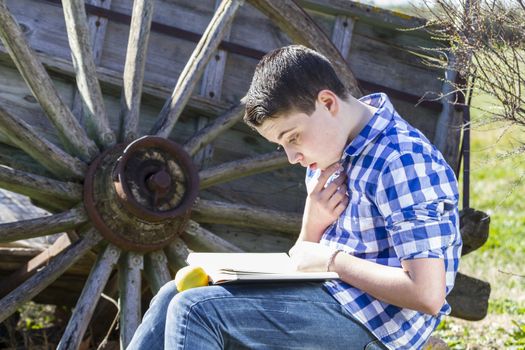 Park.Young man reading a book in outdoor with yellow apple.