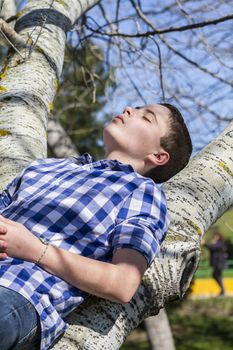 Relax.A young boy dressed in western attire, outdoor park, summer