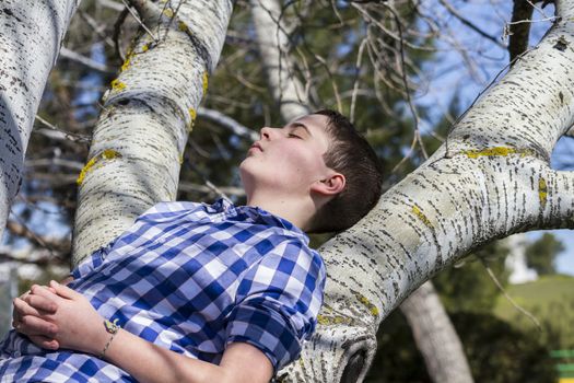 Dreaming.A young boy dressed in western attire, outdoor park, summer