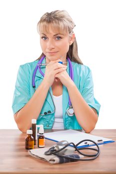 beautiful female doctor sitting at table and looking at camera