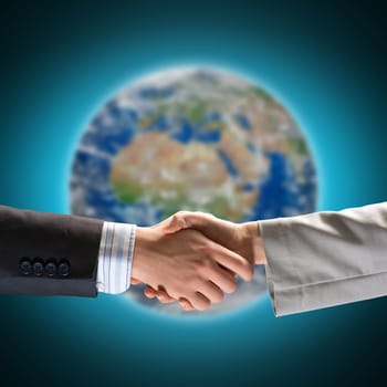 handshake of two businessmen on the background of the planet earth. Elements of this image are furnished by NASA