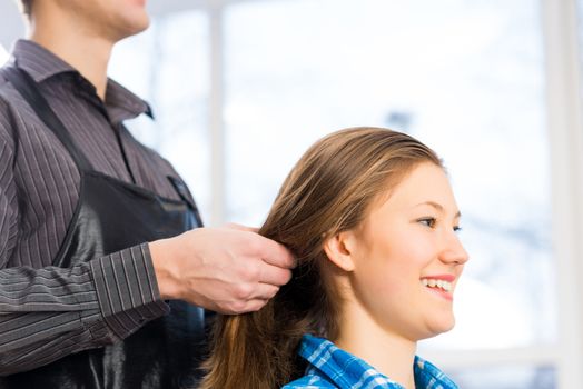 male hairdresser puts woman's hair in a hairdressing salon