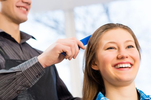 male hairdresser puts woman's hair in a hairdressing salon