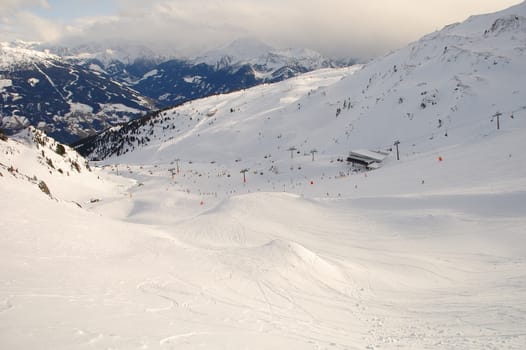 Slope and skiers in Alps nearby Kaltenbach in Zillertal valley in Austria