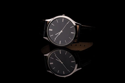 Men's wrist watch on black background. Studio shoot.