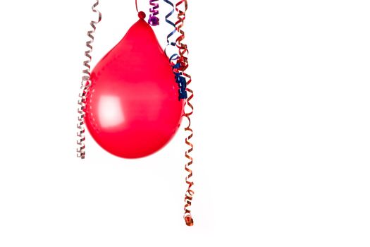 Red balloon isolated on white with hanging holiday streamers