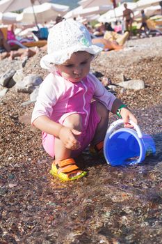 Baby play on seashore with sea water