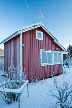 Small red cabin at winter covered in frost