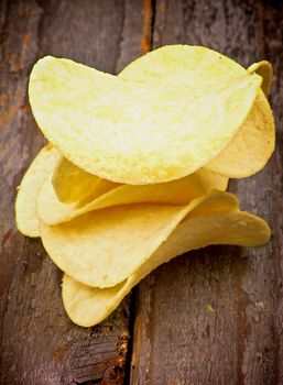 Pile of Crunchy Potato Chips isolated on Rustic Wooden background