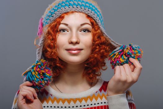 Attractive young red-haired girl in a warm knitted hat