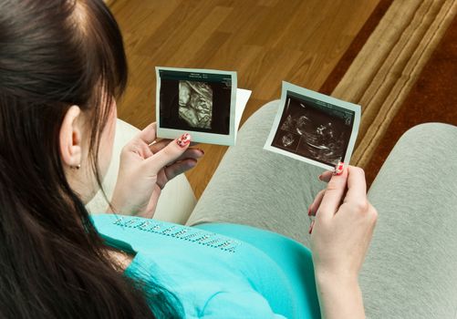 Pregnant woman watching ultrasound pictures of her baby