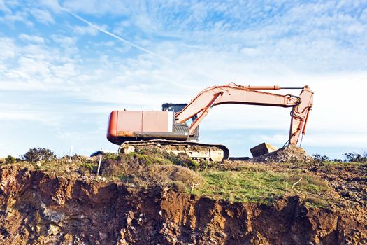 Excavator machine moves with raised bucket on construction site