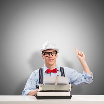 image of a young journalist, sitting at the table for a typewriter