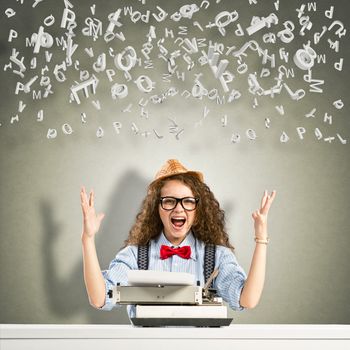 image of a young woman writer at the table with typewriter