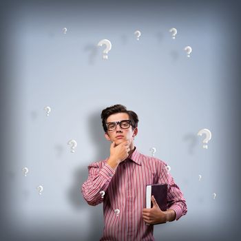 young man scientist in glasses thinking. next to it various painted symbols