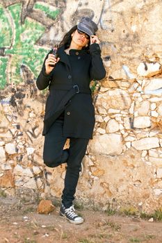 Woman in black at the graffiti brick wall