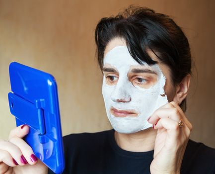 young beautiful woman takes beauty mask