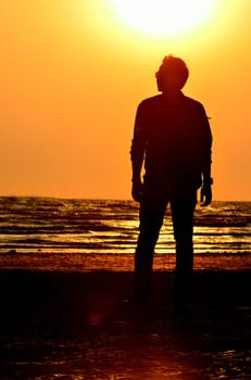 Silhouette man on beach with sunset sky background, Thailand