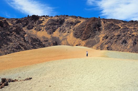 Valley El Teide. Man walking on volcanic desert