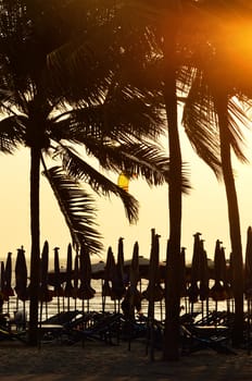 Beach chair silhouette with sunset sky