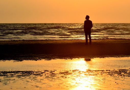 Silhouette man on beach with sunset sky background, Thailand