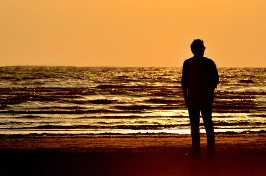 Silhouette man on beach with sunset sky background, Thailand