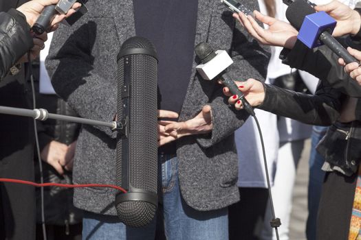 Journalist hand holding a microphone conducting an TV or radio interview