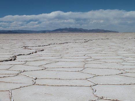 The Salinas Grandes salt flats extend over a 300 square mile area in NW Argentina. This kind of terminal high desert dry lake or salt flat occurs when water containing salt and minerals invades a low area and eventually evaporates leaving behind a deposit of salt. The area floods during the rainy season in the summer and the salt is harvested in the following winter and spring