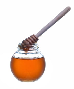 Jar of honey with wooden drizzler isolated on white background