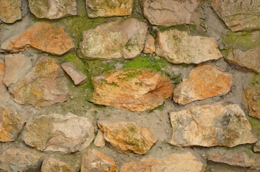 Old stone wall with green moss texture