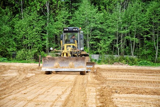 The grader clears away a ground