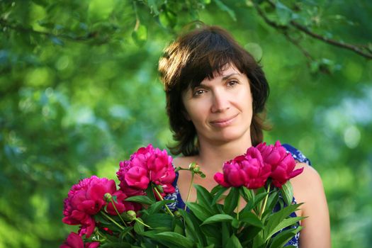 woman  in a garden with  bunch of flowers soft focus