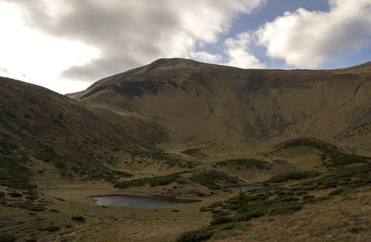 Oval lake at the foot of the mountain