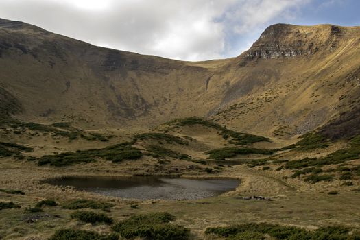 Oval lake at the foot of the mountain