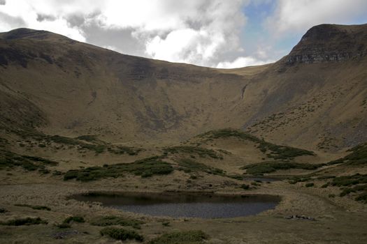 Oval lake at the foot of the mountain