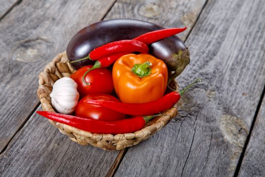 Wattled basket with vegetables on an old table