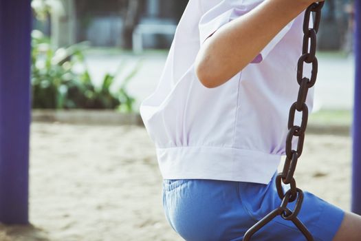 Little child on a swing in the park.