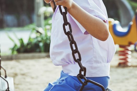 Little child on a swing in the park.