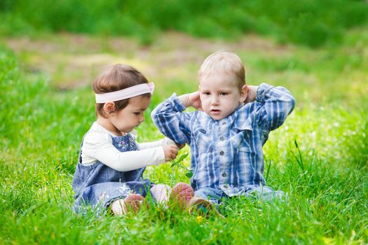 Little kids play outdoors on the grass