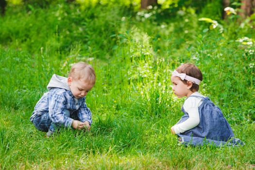 Little kids play outdoors on the grass