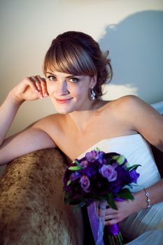 young bride with flowers on the sofa