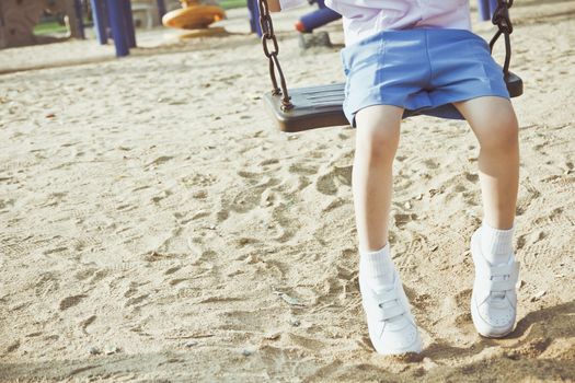 Little child on a swing in the park.