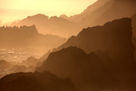 Silhouette outline of the rugged coastline in South Africa at sunset